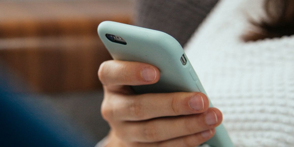 ソファでスマートフォンを手に持っている様子